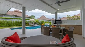 A covered outdoor area with a pool, dining setup, and a kitchen area. - Private 3 Bedroom Pool Villa MS22 (Hua Hin)