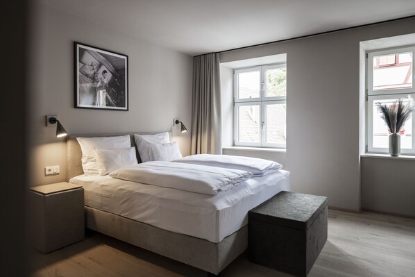 A modern bedroom with a bed, bedside tables, a window with curtains, and a framed picture on the wall. - Design Boutique Hotel & Spa Goldene Rose - Adults Only (Dinkelsbuehl)
