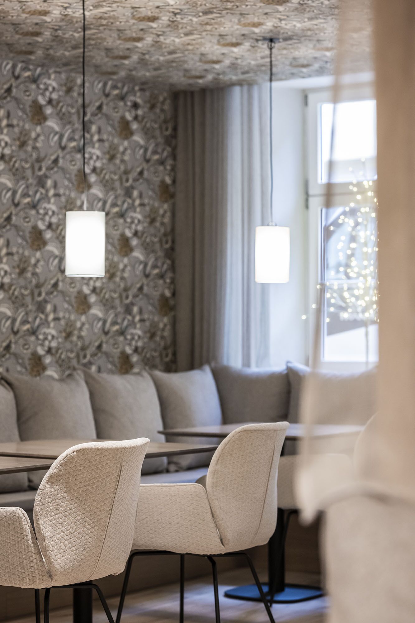 A modern dining area with a patterned wallpaper, a sofa, and a table with chairs.