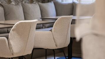 A modern dining area with a patterned wallpaper, a sofa, and a table with chairs.