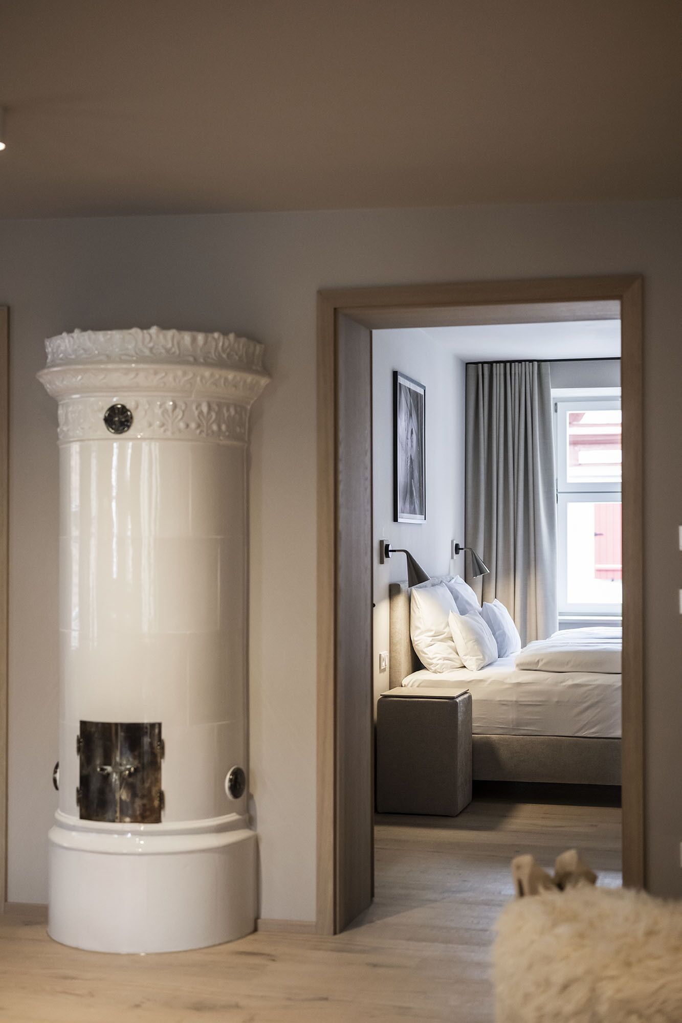 Un dormitorio con cama, lámpara de noche y un calefactor blanco grande.