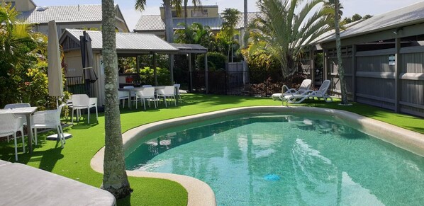 Relax by the inviting pool surrounded by lush greenery and comfortable lounge seating.