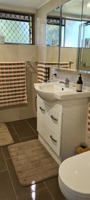 Bathroom features a sink, mirror, toilet, and towel rack.