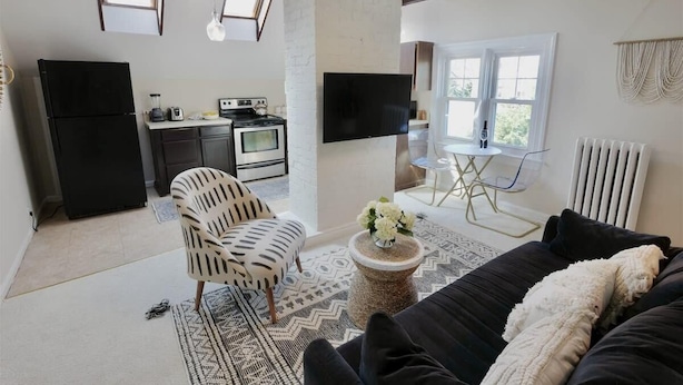 A modern kitchen with a refrigerator, stove, and dining area.