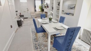 Un coin repas avec une table blanche, des chaises bleues, un tapis à motifs et un canapé blanc.