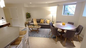 En moderne stue med sofa, sofabord, spisebord og stole.