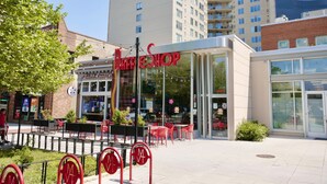 A modern building with a glass storefront and outdoor seating area. - Downtown DC Awaits with Parking Permit (Washington)
