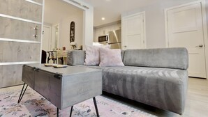 A modern living room with a grey sofa, a small side table, and a cabinet. - Downtown DC Awaits with Parking Permit (Washington)