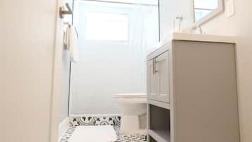 Bathtub, hair dryer, towels, shampoo