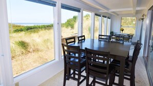 A dining area with a large table and chairs, large windows with a view of the beach and dunes. - New Listing! Cozy beachfront getaway with amazing views and miles of sandy beaches (Florence)