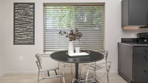 A modern kitchen with a round dining table, clear chairs, and a decorative wall piece. - Prime Location, Pet Friendly, Single Level, New Decor and Furnishing, 10 Min to PDX and Vancouver (Vancouver)