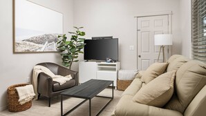 A living room with a sofa, a coffee table, a TV, a plant, and a lamp. - Prime Location, Pet Friendly, Single Level, New Decor and Furnishing, 10 Min to PDX and Vancouver (Vancouver)