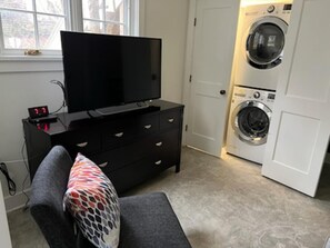 Cozy living space with a flat-screen TV, sofa, and washer and dryer.
