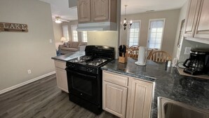 A modern kitchen with a central island, built-in cabinets, and a stove.