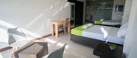 Una habitación de hotel moderna con una cama, un escritorio, una silla y una pequeña mesa con una planta.