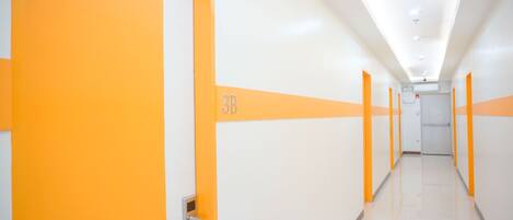 Un pasillo largo y estrecho con puertas a ambos lados, marcado con el número "3B".