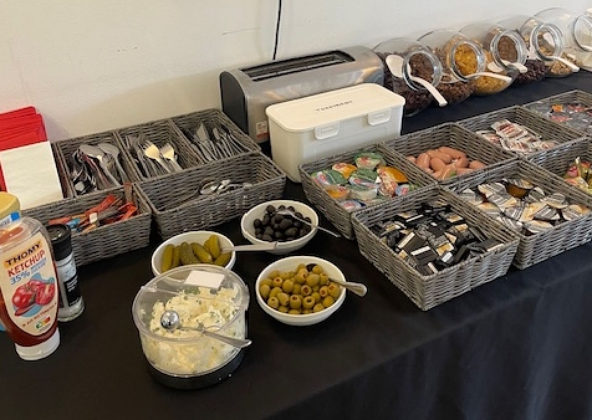 Una mesa de buffet con diversos alimentos y salsas.