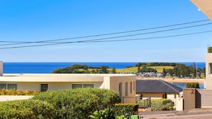 Une vue sur la côte, avec un ciel dégagé, une plage et un espace de stationnement.