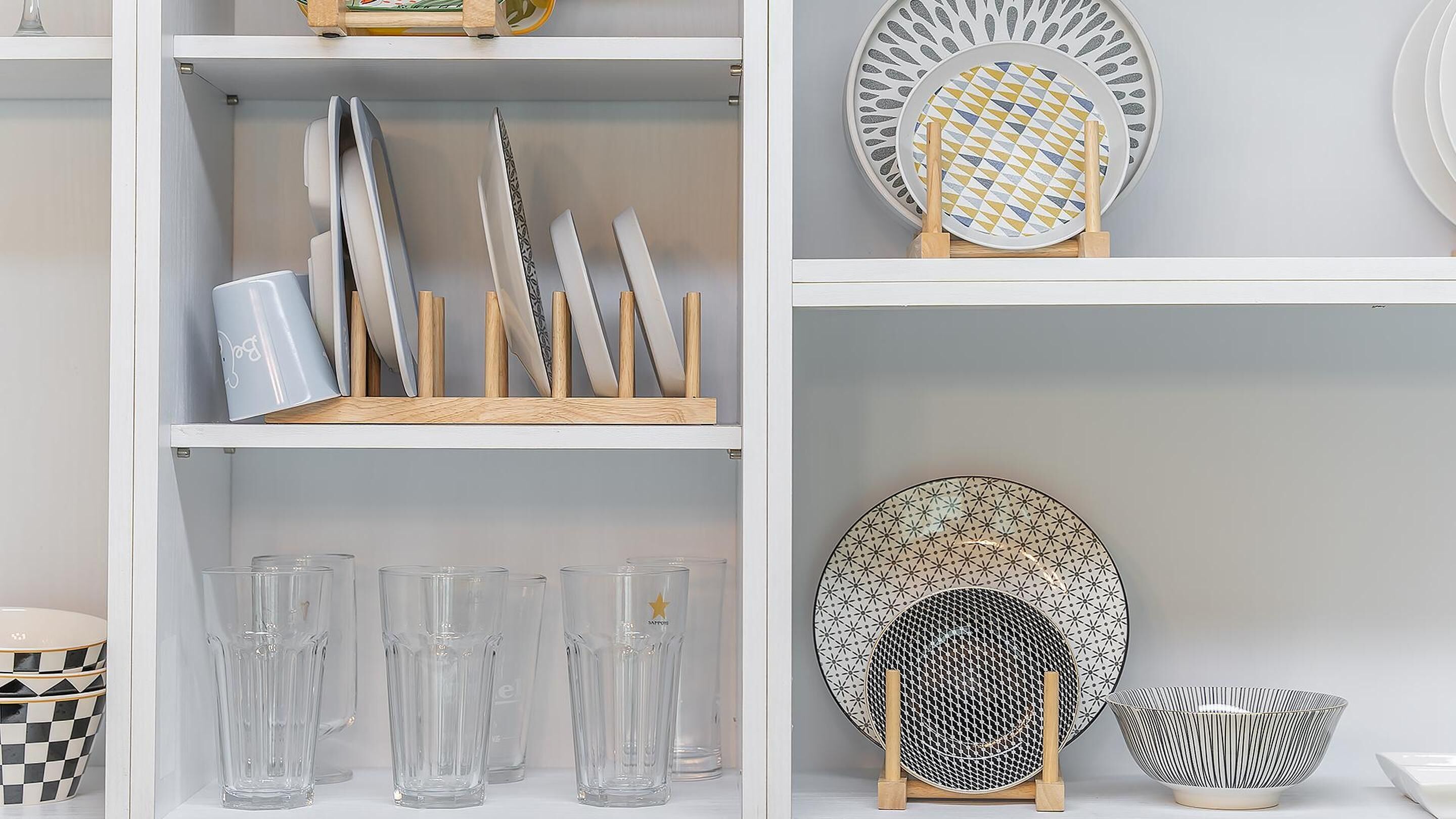 A neatly organized display of various glassware and plates on shelves.