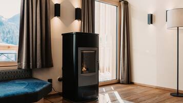 A modern living room with a wood-burning stove, a sofa, and a lamp.