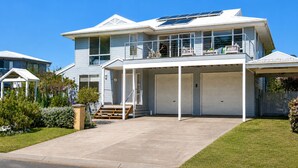 A two-story house with a covered front porch, large garage doors, and solar panels on the roof. - Seaview Cowes by Ready Set Stay (Cowes)