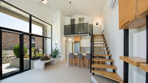 A modern interior with a staircase, a dining area, and a kitchen.