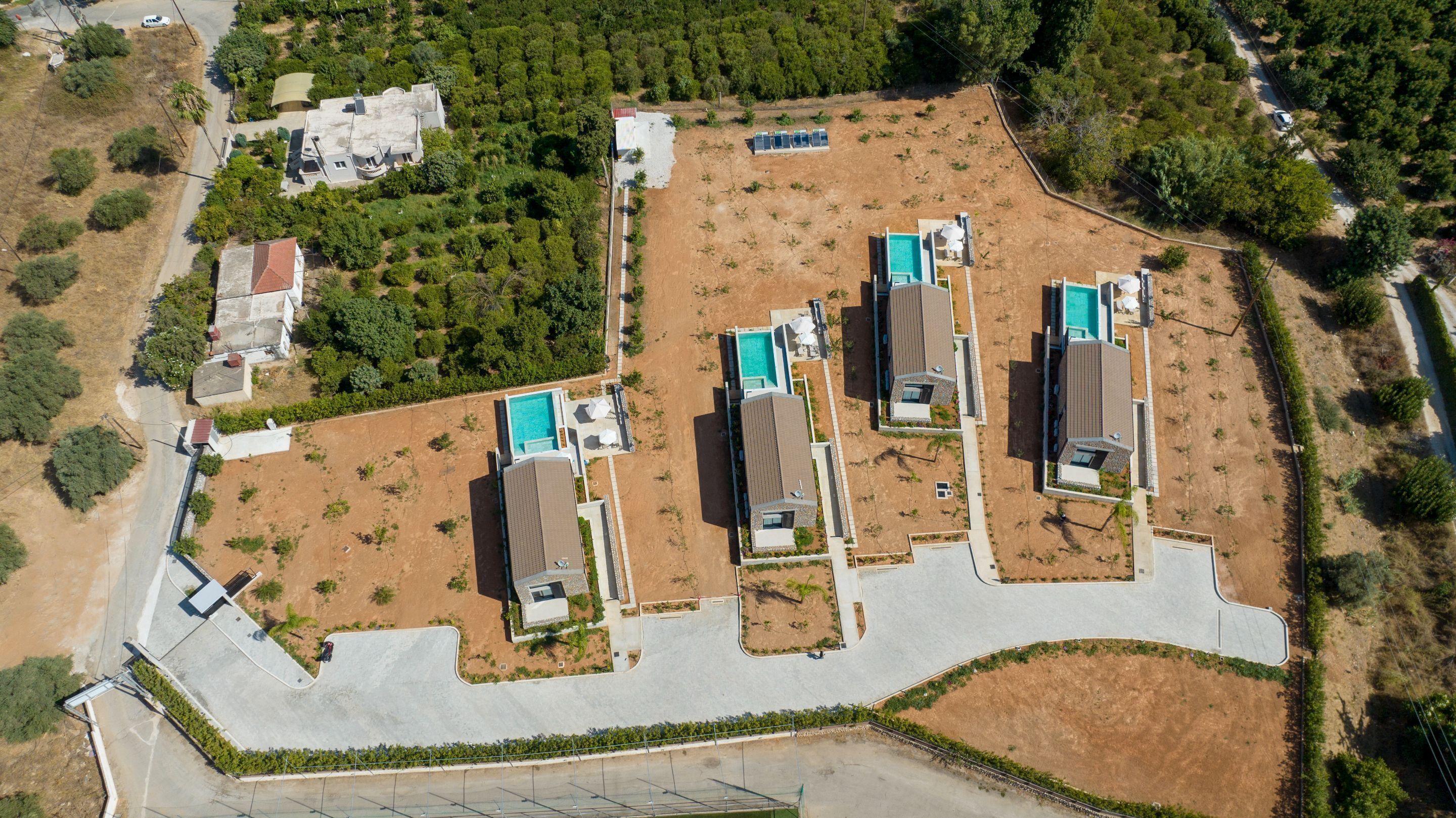 Une vue aérienne d’un quartier résidentiel avec plusieurs maisons, une piscine et une route.