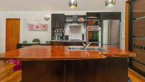 A modern kitchen with a central island, stainless steel appliances, and pendant lighting.