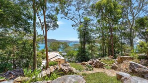 A house surrounded by trees and a view of the sea. - Pretty Beach Bay Vista by HolidayCo. (PRETTY BEACH)