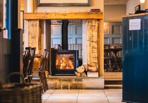 Une pièce chaleureuse avec une cheminée, des meubles en bois et un manteau de cheminée en pierre.