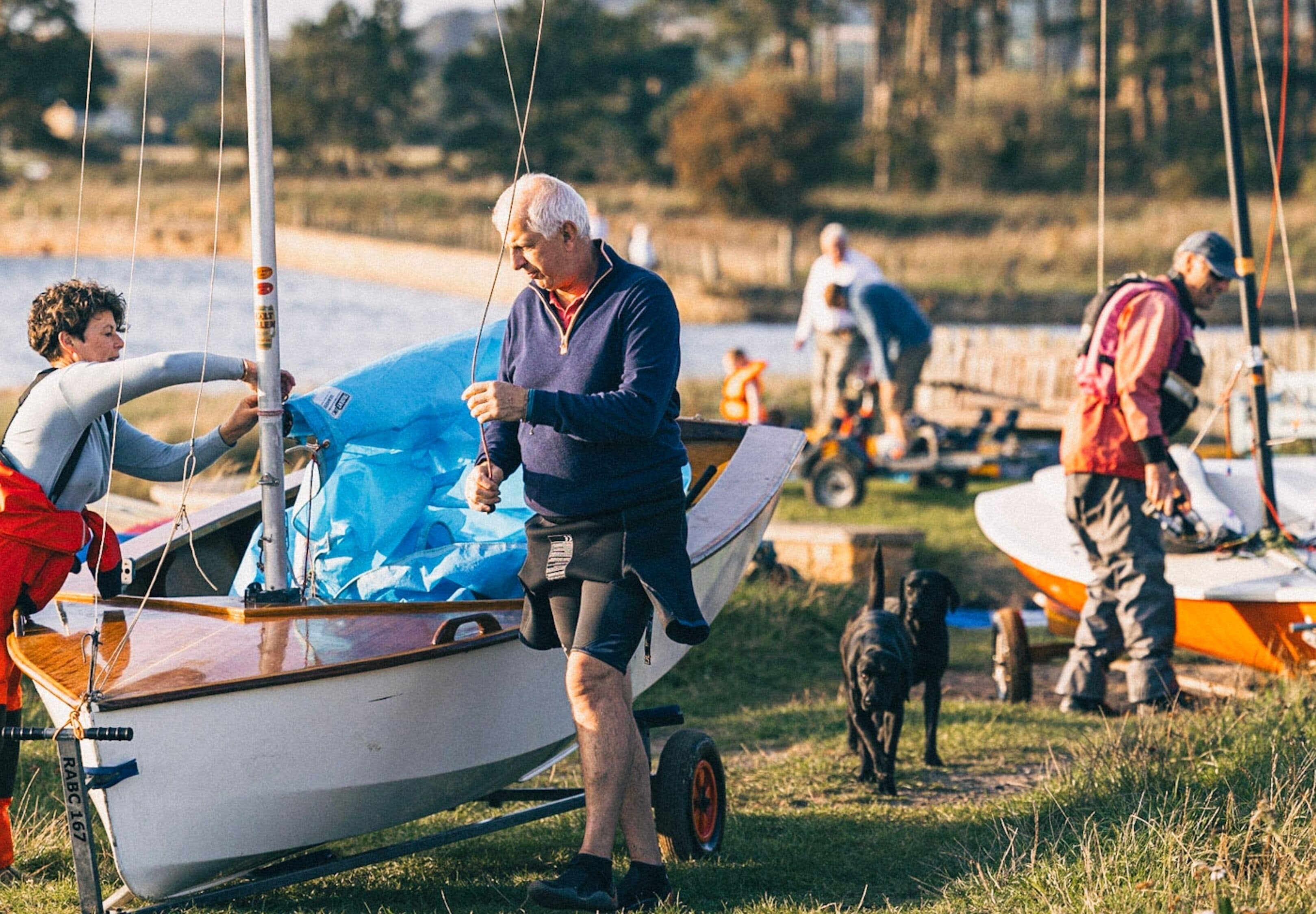 A small boat on a trailer with people around it.