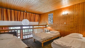 A wooden cabin room with three beds, a balcony, and a wall-mounted photo display. - Duplex Studio 5 pers. in Central Morzine, near Slopes (Morzine)