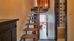 A wooden staircase leading to a loft bedroom with a view of a garden. - Duplex Studio 5 pers. in Central Morzine, near Slopes (Morzine)