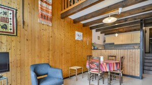 A wooden interior with a blue chair, a wooden bench, and a dining table with chairs. - Duplex Studio 5 pers. in Central Morzine, near Slopes (Morzine)