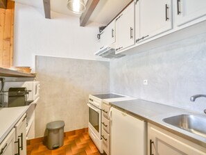 A compact kitchen with white cabinets, a stainless steel sink, and a small trash bin. - Duplex Studio 5 pers. in Central Morzine, near Slopes (Morzine)