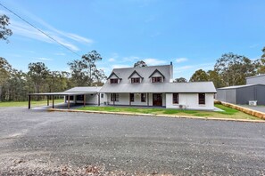 A two-story house with a covered porch and a garage. - Kitchener Country Estate with Pool Hot Tub (Kitchener)