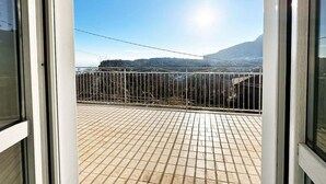 A balcony with a tiled floor and a metal railing, overlooking a mountainous landscape. - Lovely 6-bed Apartment on the Amalfi Coast (Amalfi)