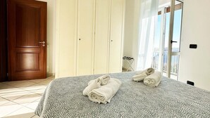 A bedroom with a bed, a wardrobe, and a window with curtains. - Lovely 6-bed Apartment on the Amalfi Coast (Amalfi)