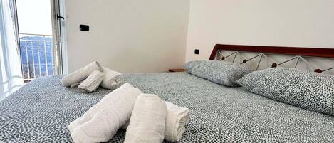 A hotel room with a bed, pillows, and towels.
