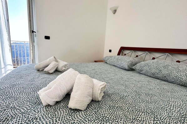 A hotel room with a bed, pillows, and towels.