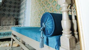A room with a wooden bench, a blue cushion, and a patterned wall. - Bit HSAN :Original guestroom (Mahdia)