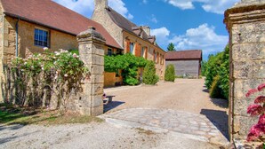 Un edificio de piedra con un camino de grava y una puerta de piedra.