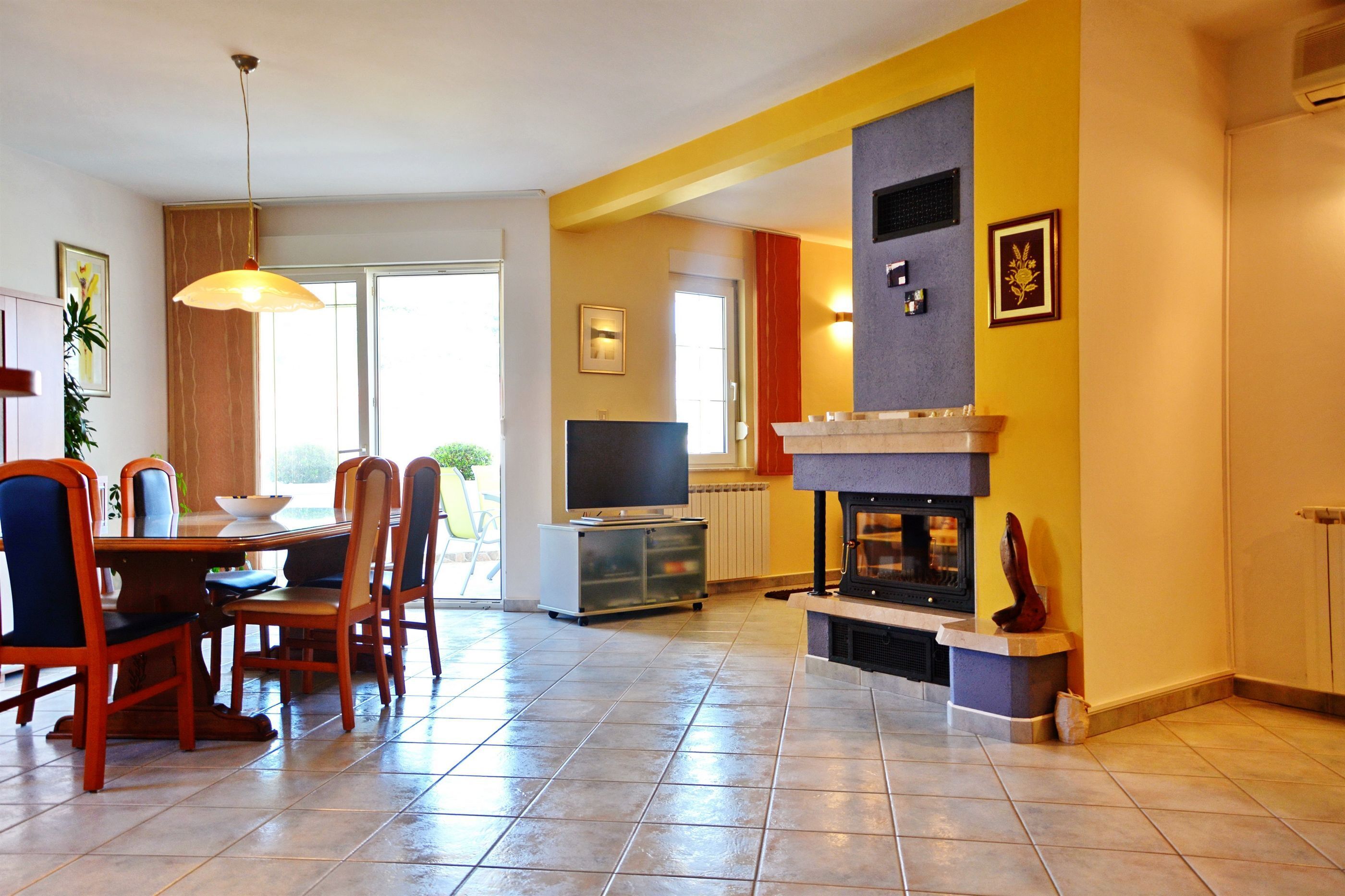 Un comedor con una mesa, sillas, un televisor y una chimenea.