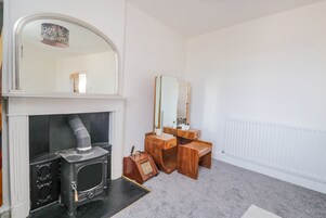 A room with a fireplace, a mirror, a vanity, and a radiator.