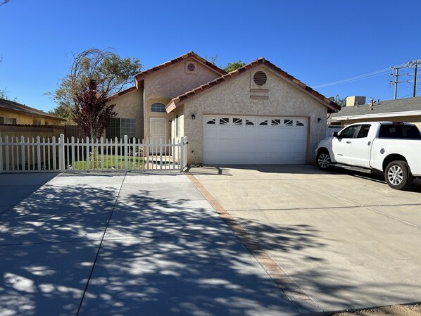 A two-story house with a garage, a white picket fence, and a parked white truck. - Cheerful 3BR 2BA Sauna: Spa: Pool/P-Pong Table+ More (Lancaster)