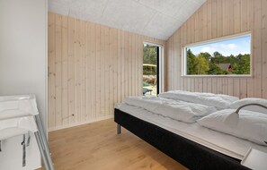 A bedroom with a bed, a window, and a view of the outdoors.