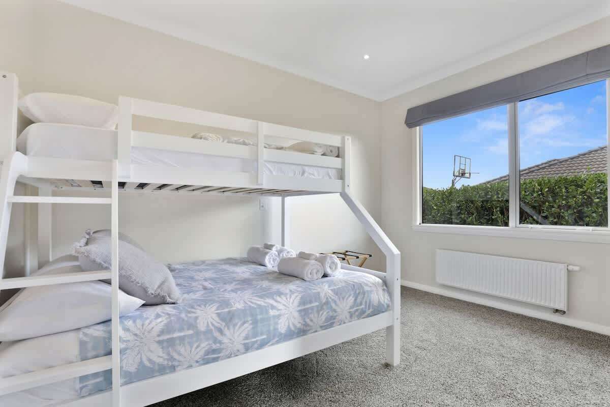 A bunk bed room with a view of greenery outside.