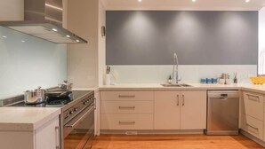Eine moderne Küche mit Edelstahlgeräten, einem Backofen und einem Geschirrspüler.