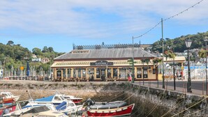A waterfront building with a sign reading "PLATFORM 1" and various amenities like fresh char, champagne, and lobster.
