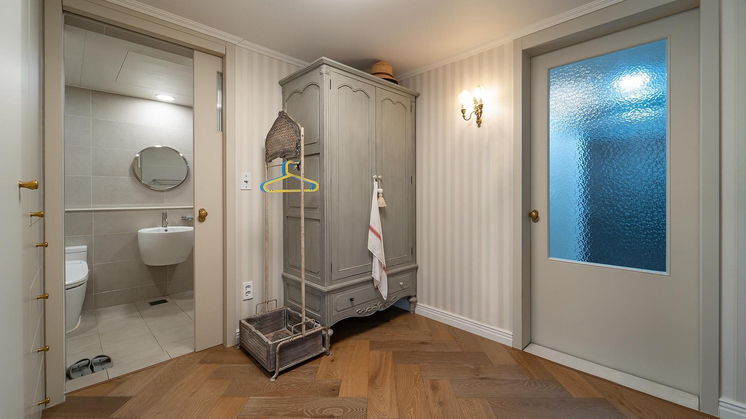 A bathroom with a toilet, sink, and a large mirror.